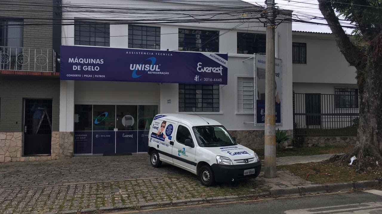 Fachada da Unisul Refrigeração no bairro Água Verde, em Curitiba, com veículo de atendimento estacionado